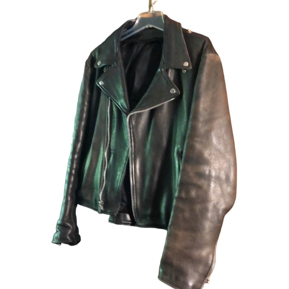Black motorcycle jacket. Ripped zipper on one of the sleeves. Slight discolored